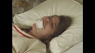 Pretty brunette in Straitjacket taped mouth forced tied to bed hospital